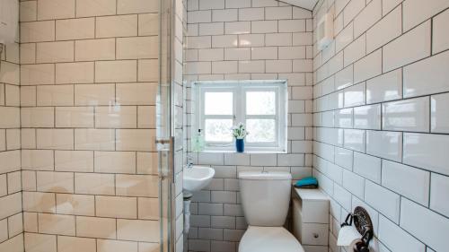 bagno con servizi igienici, lavandino e finestra di The Old Weighbridge a Bakewell