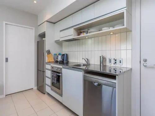 a kitchen with a sink and a stove at Wynyard Viaduct Harbour 2BR and Parking Zodiak Stays in Auckland