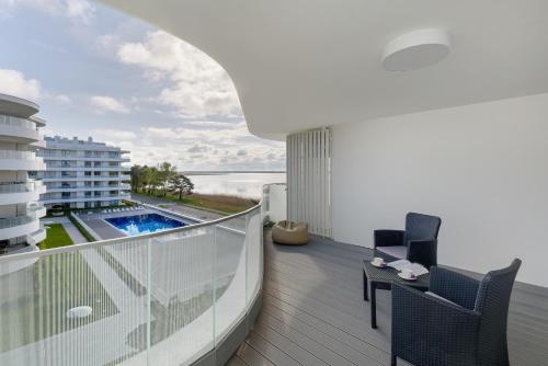 a balcony with a view of a swimming pool on a building at Przytulny apartament Perła Bałtyku in Rogowo