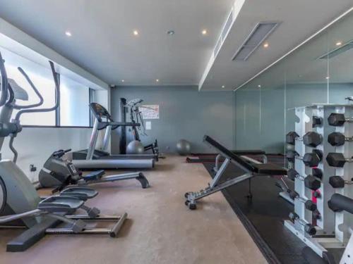 a gym with several exercise bikes and treadmills at Wynyard Viaduct Harbour 2BR and Parking Zodiak Stays in Auckland