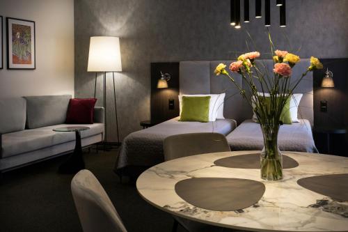 a hotel room with a vase of flowers on a table at Hotel Atrium in Kraków