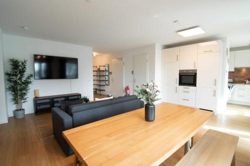a living room with a black couch and a wooden table at Central Apartment 4 Bedrooms for up to 12 Guests in Hamburg