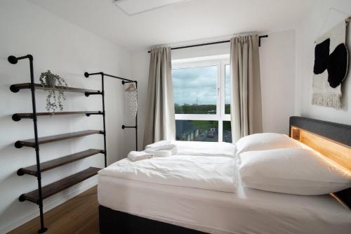1 dormitorio con cama blanca y ventana en Central Apartment 4 Bedrooms for up to 12 Guests, en Hamburgo