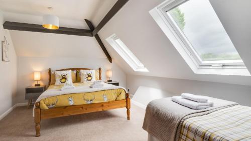 a bedroom with two beds and two skylights at The Coach House - Lea 