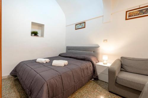 ein kleines Schlafzimmer mit 2 Betten und einem Stuhl in der Unterkunft Casa Vita 51 in Ceglie Messapica