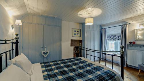 クロムフォードにあるCalamine Cottageのベッドルーム1室(ベッド1台、プライド毛布付)