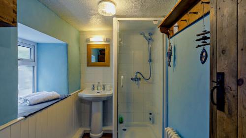 La salle de bains est pourvue d'une douche et d'un lavabo. dans l'établissement Calamine Cottage, à Cromford