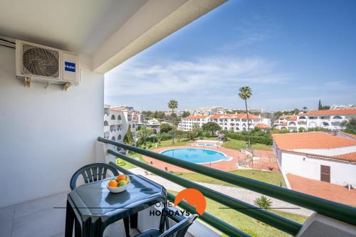 a balcony with a table and chairs and a pool at #079 Center City with Pool, AC in Albufeira
