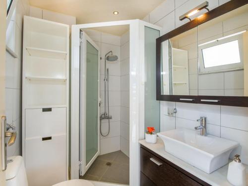a white bathroom with a sink and a mirror at The Seaside Villa in Chania Town