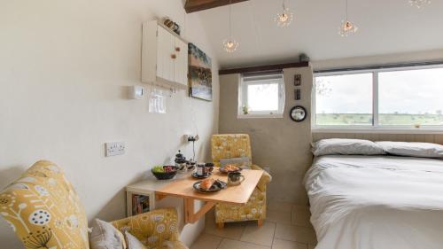 Habitación pequeña con cama, mesa, cama y escritorio. en The Potting Shed, en Longnor