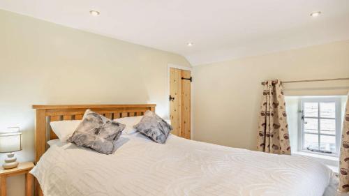 a bedroom with a bed with two pillows on it at Hobcroft Cottage in Warslow