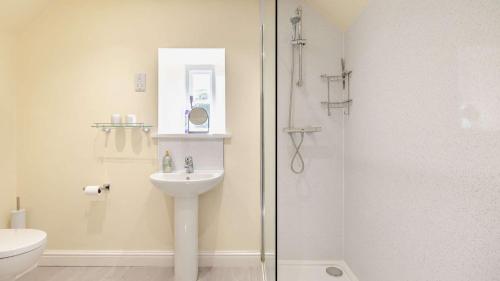 a bathroom with a sink and a glass shower at Hobcroft Cottage in Warslow