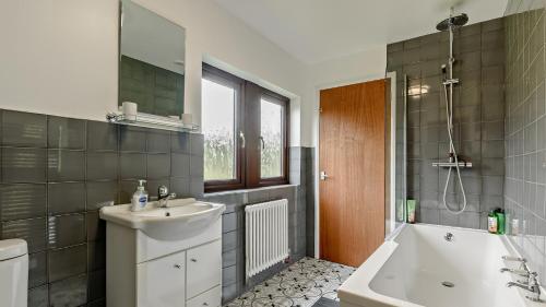 uma casa de banho com um lavatório, uma banheira e um WC. em The Catlow em Parwich