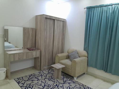 دار الكيان للشقق المخدومة - Dar Al Kayan Serviced Apartments في جدة: غرفة معيشة مع كرسي ومرآة