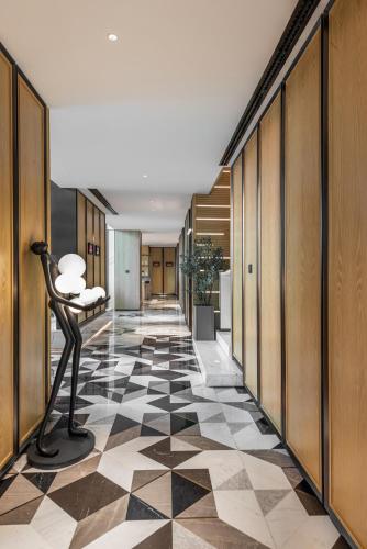a hallway with a black and white checkered floor at Narcissus The Royal Hotel in Riyadh