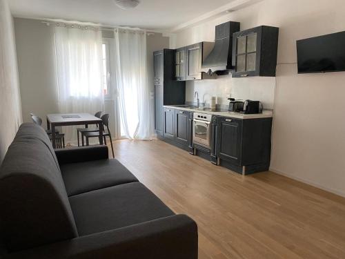 a living room with a couch and a kitchen at Welc-ōM Padova Santa Sofia in Padova