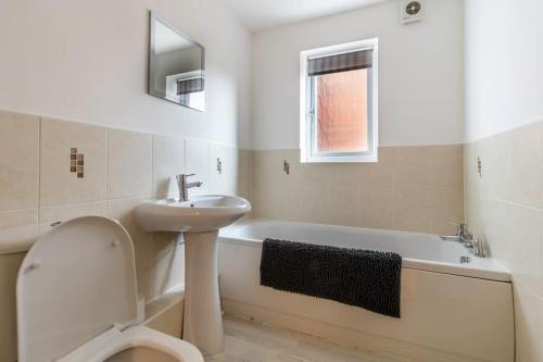 a white bathroom with a sink and a bath tub at 2 Bedroom Flat, Glasshoughton in Castleford