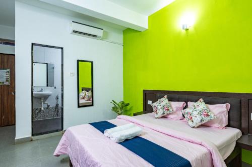 a bedroom with a large bed with a green wall at Palash Villa in Aguada