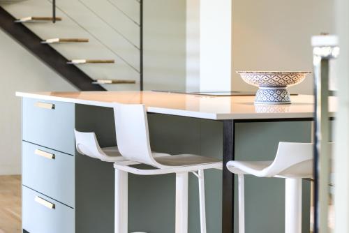 a kitchen with a counter with two white chairs at Villa - Piscine - Spa - Vue imprenable - Terrasse in Baden
