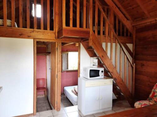 Cette chambre comprend une cuisine équipée d'un four micro-ondes. dans l'établissement Chalet 6 personnes, à Taussac