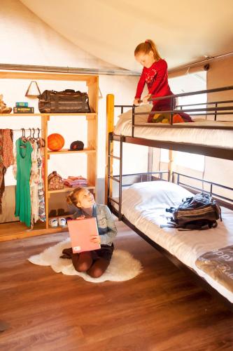 a child sitting on the floor in a bunk bed at Safaritent in Alphen