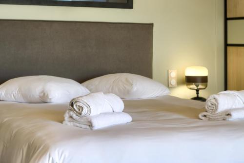a bed with white towels and pillows on it at Villa - Piscine - Spa - Vue imprenable - Terrasse in Baden
