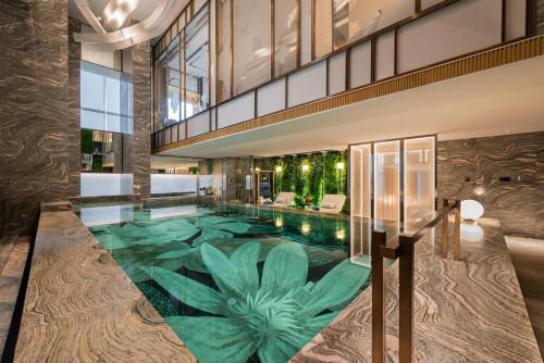 فندق نارسس ذا رويال في الرياض: مسبح داخلي بالنباتات الخضراء في مبنى
