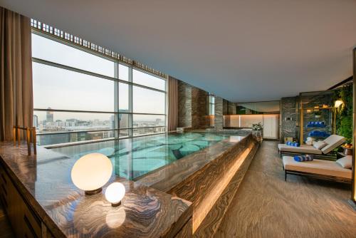 a large swimming pool in a building with a large window at Narcissus The Royal Hotel in Riyadh