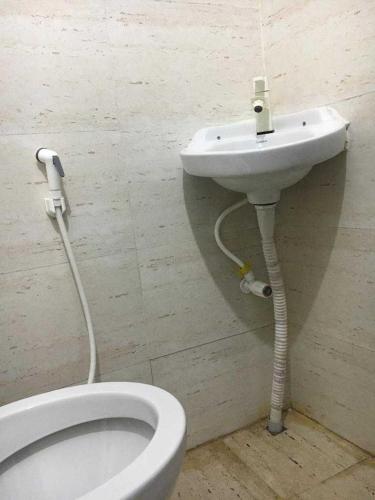 ein Badezimmer mit einem weißen WC und einem Waschbecken in der Unterkunft OYO Hotel The Limestone in Indraprast