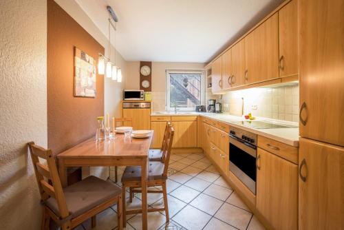 a kitchen with a wooden table and a dining room at Ferienwohnung Krempermoor 1 in Krempermoor