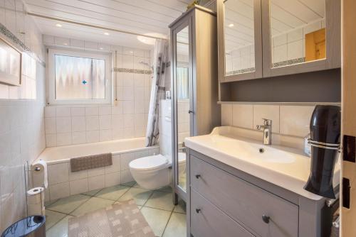 a bathroom with a sink and a toilet and a tub at Ferienwohnung Krempermoor 1 