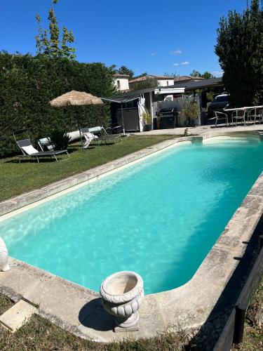 une piscine avec un planteur au milieu dans l'établissement chalet sous le chant du chêne, à La Roque-dʼAnthéron
