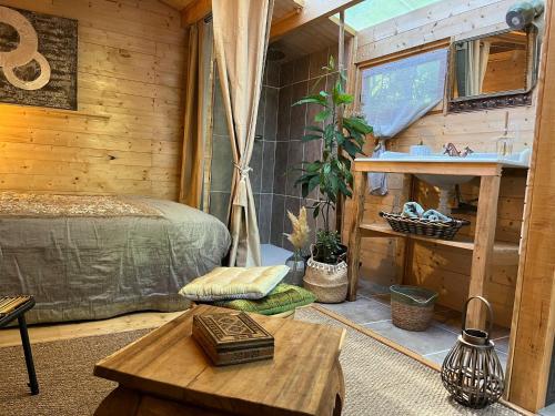a room with a bed and a table and a window at chalet sous le chant du chêne in La Roque-dʼAnthéron