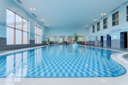 uma piscina num edifício com azulejos azuis em McWilliam Park Hotel em Claremorris