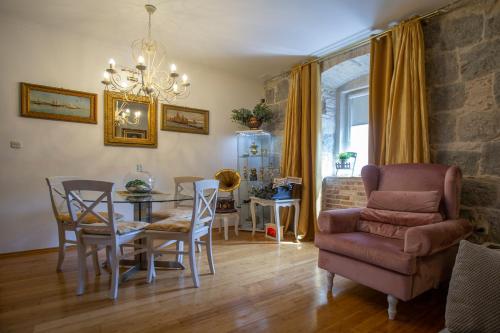 ein Wohnzimmer mit einem Esstisch und einem Stuhl in der Unterkunft Split Theatre Apartments in Split