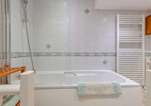 uma casa de banho com uma banheira e uma toalha. em Chabar em Swanage
