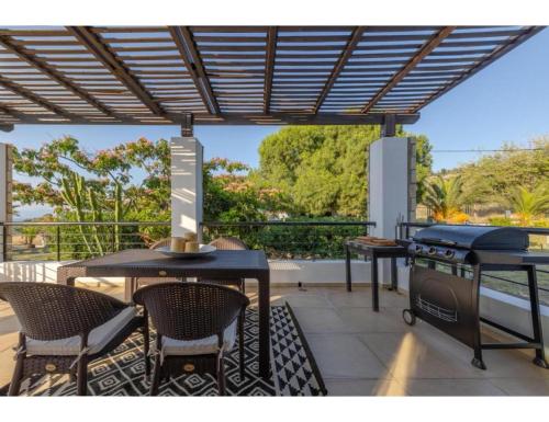 a patio with a grill and a table and chairs at Casa Natura in Psalidi