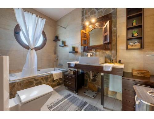 een badkamer met een bad, een toilet en een wastafel bij Casa Natura in Psalidi