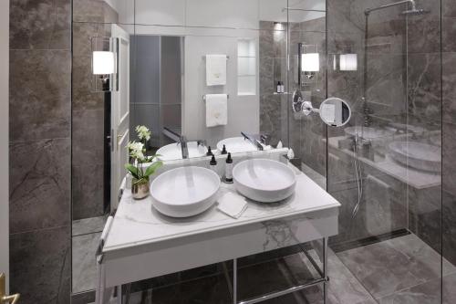 a bathroom with two sinks and a shower at Hotel Zur Wiener Staatsoper in Vienna