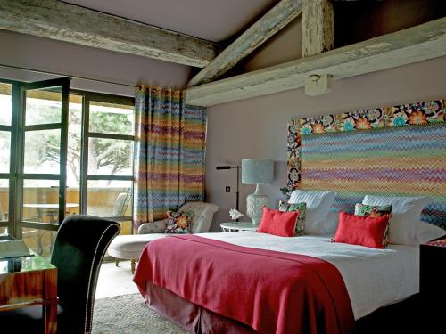 a bedroom with a large bed with a red blanket at Hôtel Villa Marie Saint Tropez in Saint-Tropez