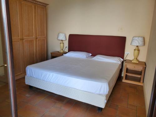 a bedroom with a bed and two lamps on tables at Residence Il Vigneto in Oggebbio