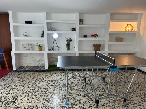 una mesa de ping pong en una habitación con estanterías blancas en Casa amplia, confortable, céntrica by Prishomes, en Vigo