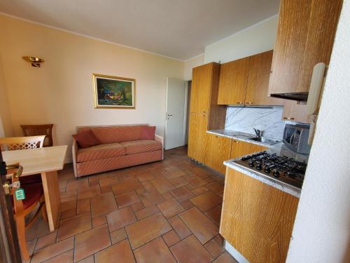 Il comprend un salon avec un canapé et une cuisine. dans l'établissement Residence Il Vigneto, à Oggebbio