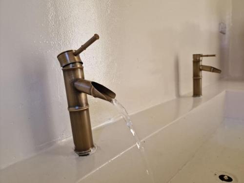 a water faucet with water coming out of it at Luxury White Villa in Nungwi
