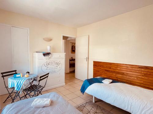 a bedroom with a bed and a table and chairs at Appartement 2 chambres à 100 m de la plage in Fréjus