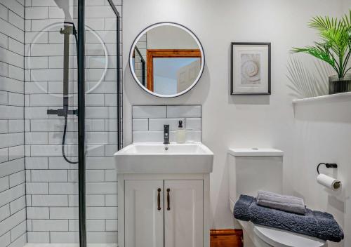 uma casa de banho branca com um lavatório e um espelho em The Castleman em Ferndown