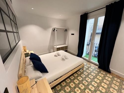 Un dormitorio con una cama grande y una ventana en Apartamenticos El Tubo I, en Zaragoza