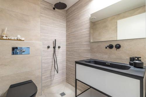 La salle de bains est pourvue d'un lavabo et d'une douche. dans l'établissement Magical 2BR Parking with amazing view in city gate, à Jérusalem