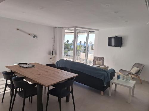 Cette chambre comprend un lit, une table et des chaises. dans l'établissement Apartamento en primera línea de mar de Salou, à Salou