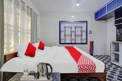 um quarto com uma cama branca e almofadas vermelhas em Flagship Comfort By Comfay em Srinagar